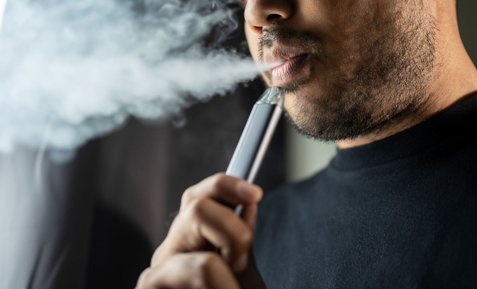 A person using a modern disposable vape device
